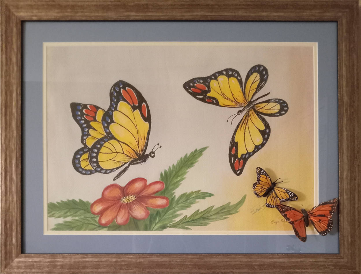 Colourful butterflies hovering over a flower, with two silk butterfies glued to the glass covering