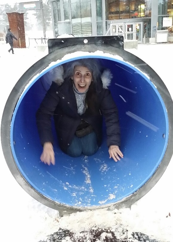 Sliding out through the tunnel at a children's playground in the winter.